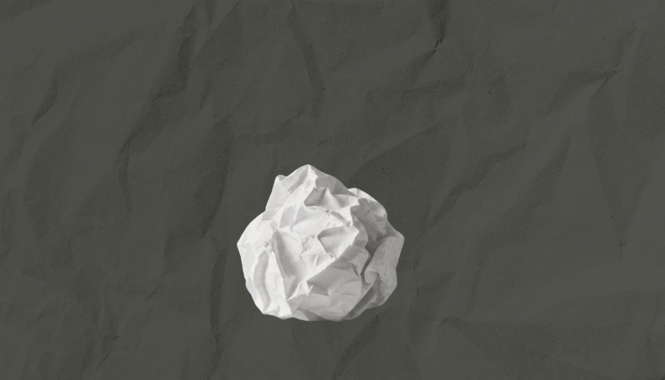 A crumpled ball of white paper against a dark background